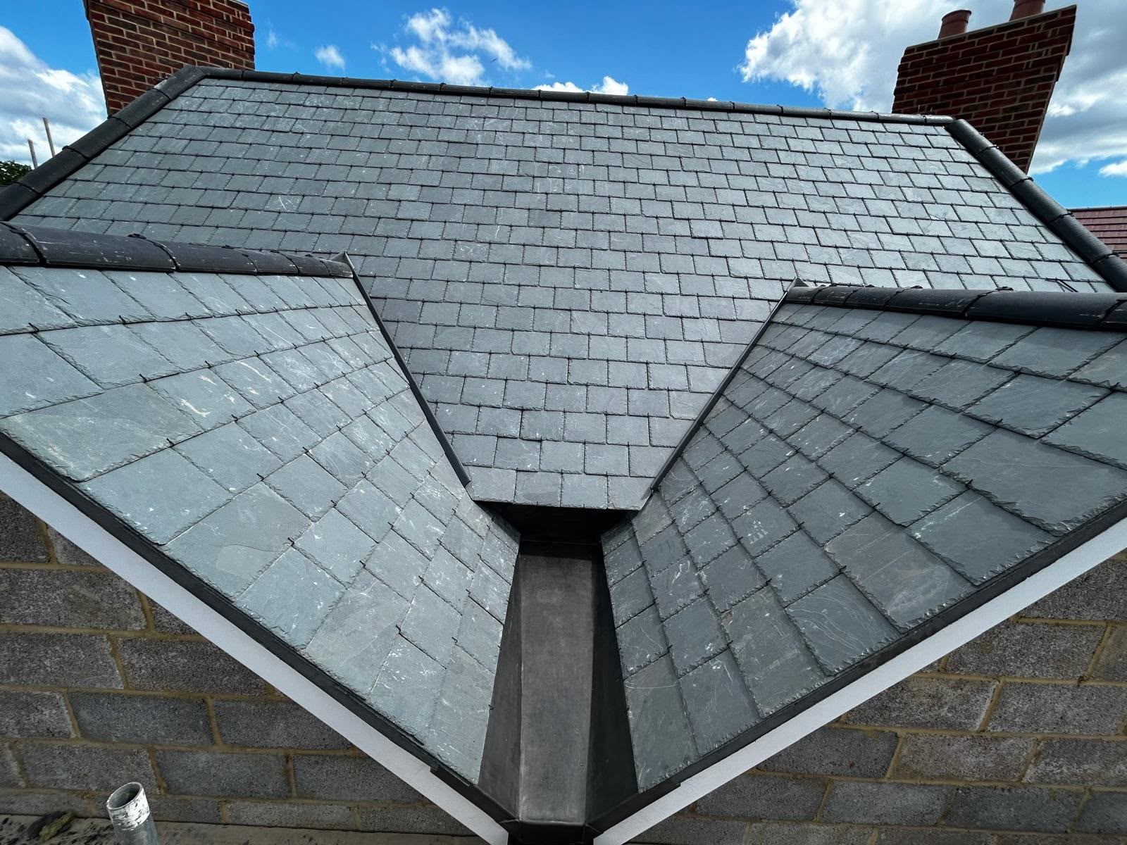 A natural slate roof, two valleys meeting under a lead ridge